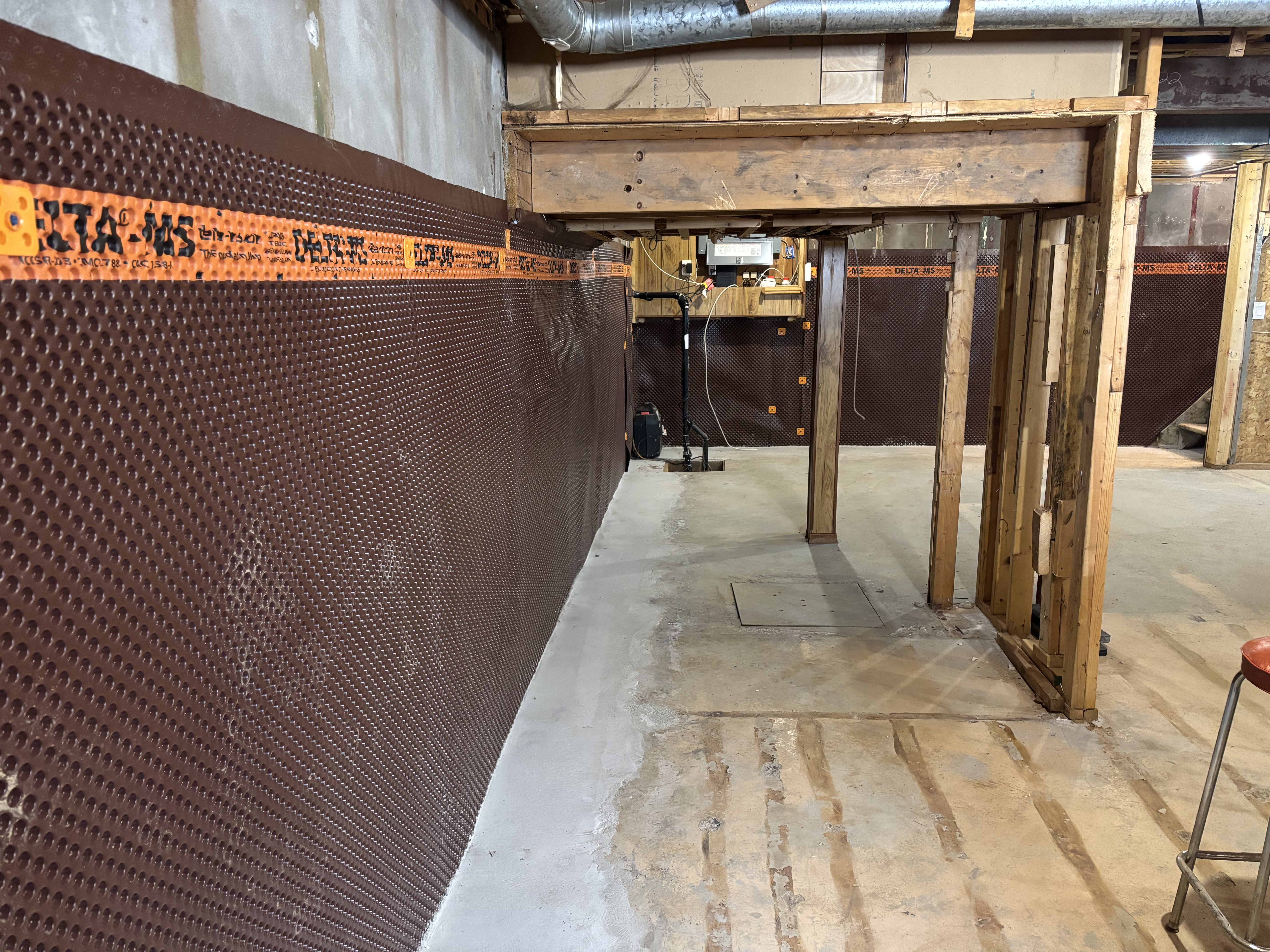 Finished basement with Delta-MS membrane on the walls and new concrete poured over the drainage channel