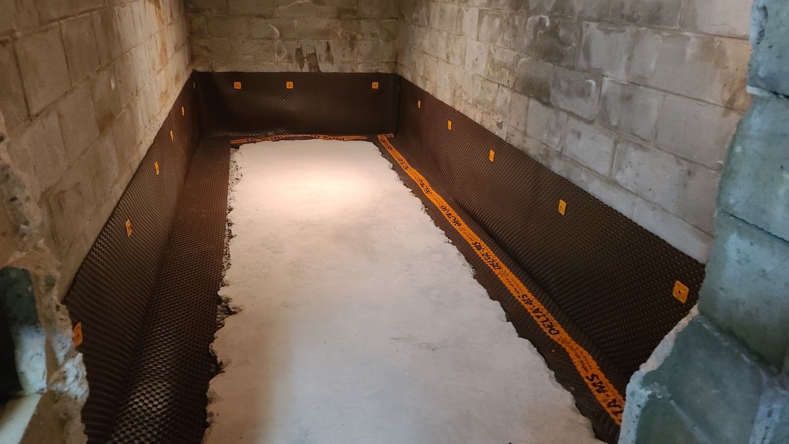 Delta-MS drainage membrane installed along a basement foundation wall