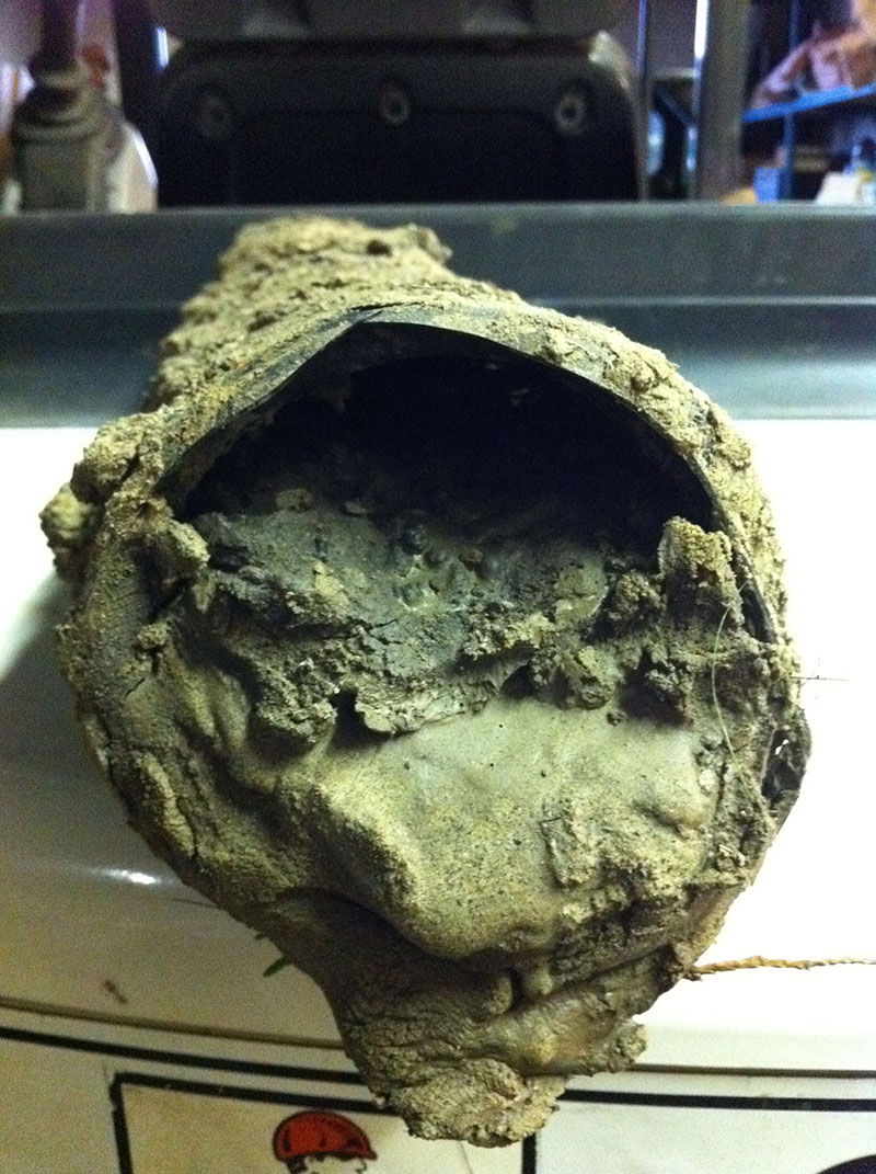 Weeping tile pipe cut open and packed solid with hardened sediment