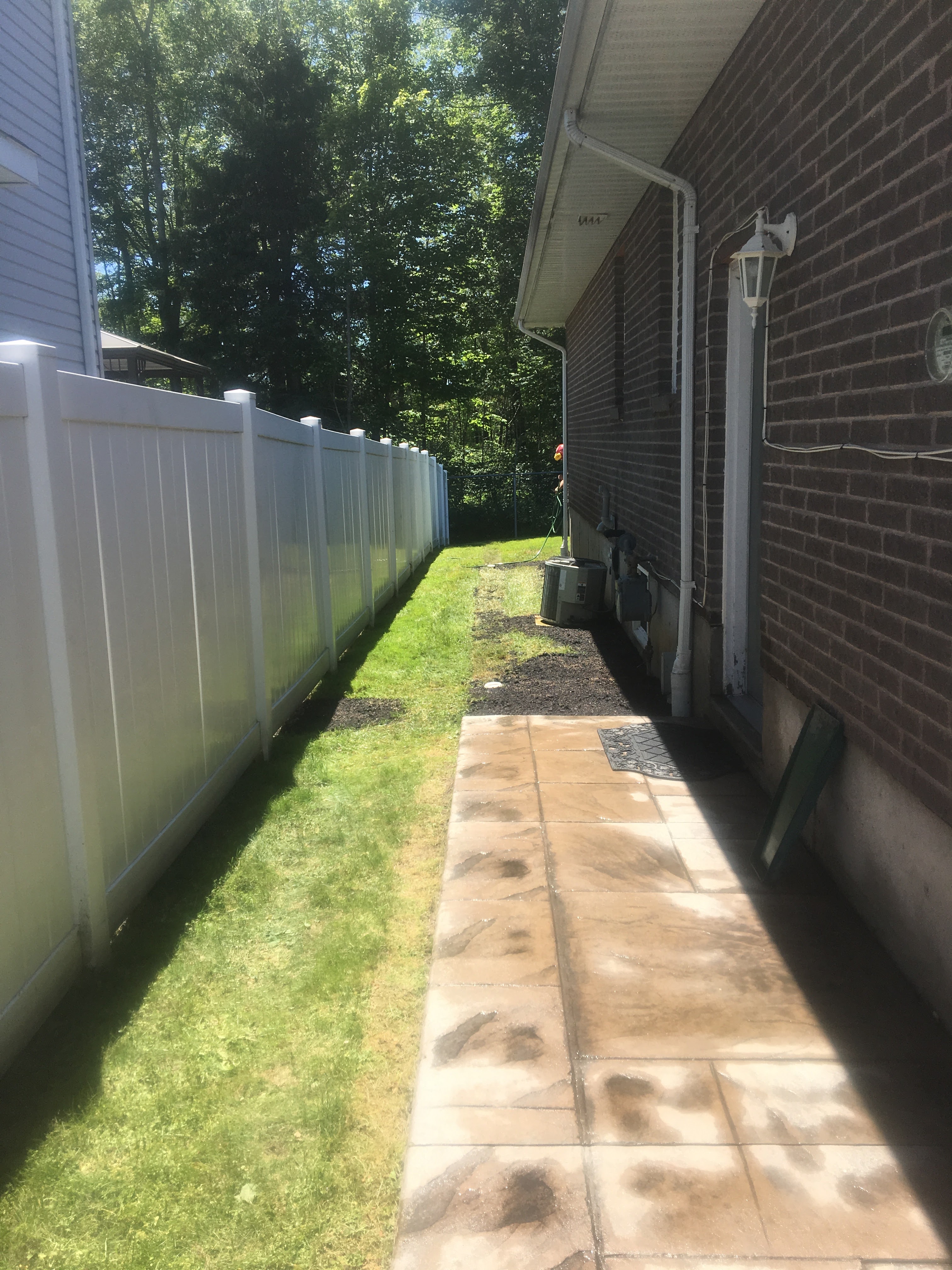 Finished side yard with restored lawn and walkway after drainage installation